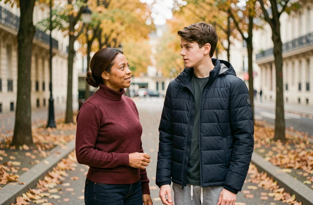 Une mère et son fils adolescent partageant un moment de discussion authentique sur un trottoir parisien en automne